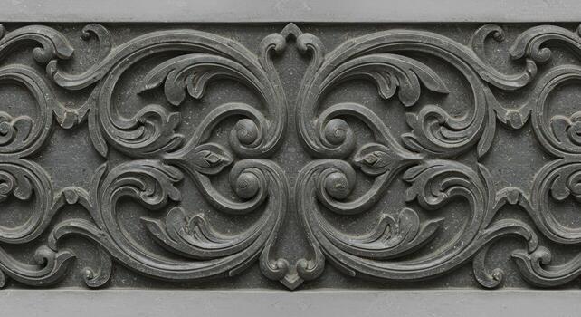 Intricate floral carvings embellish an ornate gray stone border pattern with swirling vines and elegant designs in this detailed close up view. photo