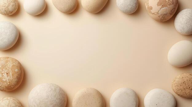 Minimalist arrangement of smooth beige stones creates a natural frame on a light background ideal for text overlay and design elements. photo