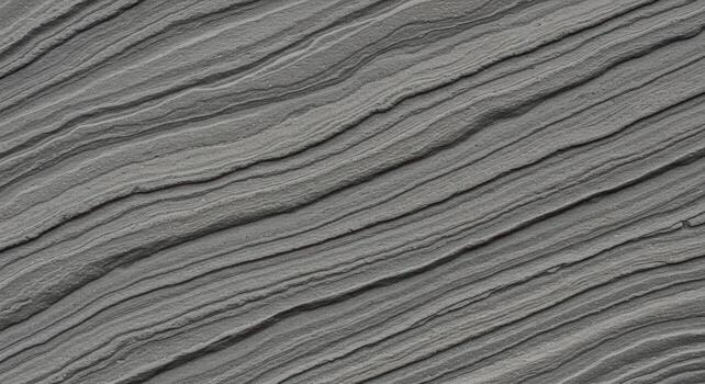 A textured gray surface shows diagonal lines and grooves, creating a natural stone or rock formation pattern with subtle variations. photo