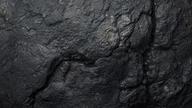 Detailed macro shot showcases the irregular surface and deep black color of a natural coal formation in a dimly lit environment showcasing texture. photo