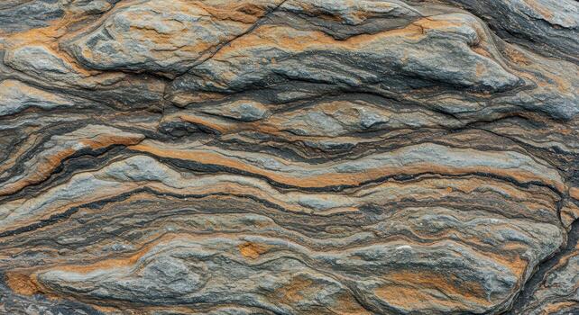 The intricate layers of sedimentary rock display a captivating dance of gray, black, and orange tones, showcasing natures artistry over time. photo