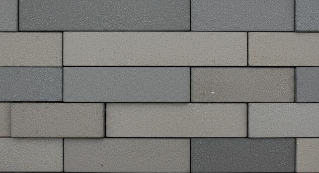 A close up of a gray brick wall shows its simple rectangular pattern and textured surface creating a modern industrial background design. photo