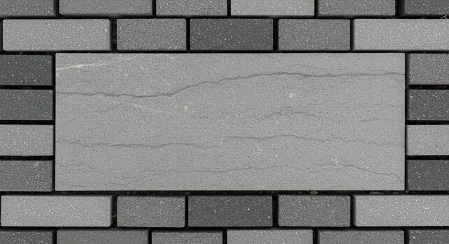 A neatly arranged rectangular stone tile with textured surface framed by dark gray brick stones creates an interesting architectural background. photo