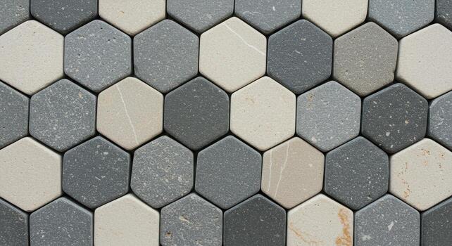 Abstract geometric pattern of grey and beige hexagonal tiles arranged closely together creating a textured surface for backgrounds and designs. photo