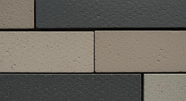 Close up of a meticulously arranged pattern of gray and tan brickwork creating a textured and modern architectural design element for exteriors. photo