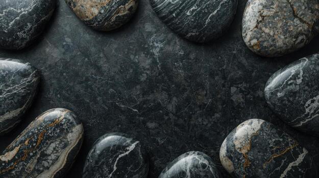 Natural smooth stones with dark textures border a textured gray stone surface creating a peaceful, balanced, organic backdrop scene. photo
