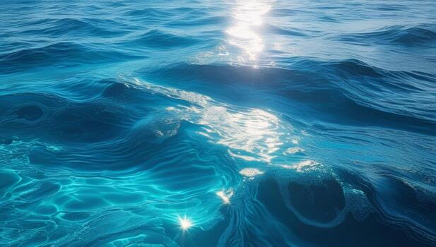 Sunlight dancing across the surface of a vibrant ocean with rippling turquoise waves photo