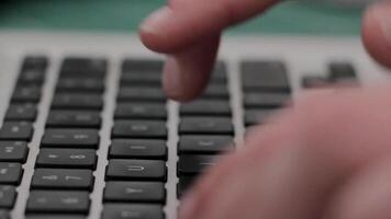 uma pessoas mão é em uma computador portátil teclado video
