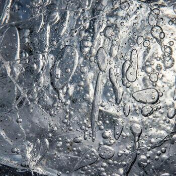 Abstract close up of shimmering water surface with numerous air bubbles and light reflections creating a dynamic texture photo