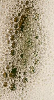 cerca arriba resumen ver de numeroso pequeño y grande burbujas formando un texturizado modelo en un ligero de colores superficie foto