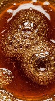 Close up macro view of golden brown liquid with numerous small bubbles forming interesting patterns and textures photo
