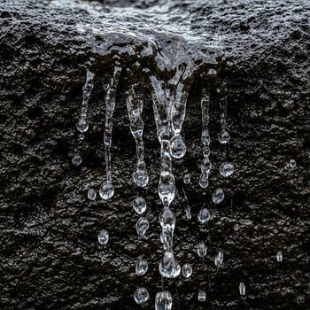 Abstract close up of water dripping down a dark textured surface creating a mesmerizing visual effect photo
