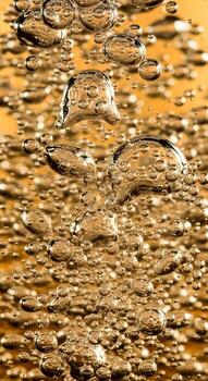 Close up abstract view of tiny golden bubbles rising through a textured surface creating a mesmerizing pattern photo