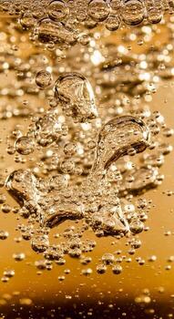 Abstract close up of golden bubbles and liquid surface reflecting light in a dynamic and textured pattern photo