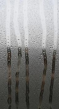 Abstract macro view of water droplets on glass with blurred vertical lines creating a textured atmospheric effect photo