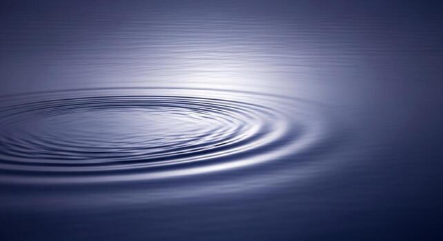 Close up of concentric ripples spreading across the surface of calm deep blue water creating a mesmerizing abstract pattern photo