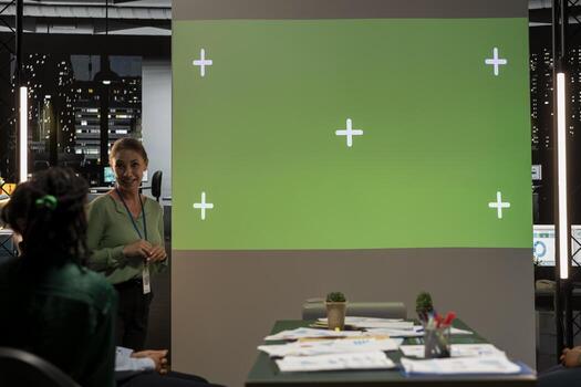 Multiethnic project team works late in a dark office with copy space, collaborating on budgeting, reporting and setting business goals during a night meeting at a multinational company. photo