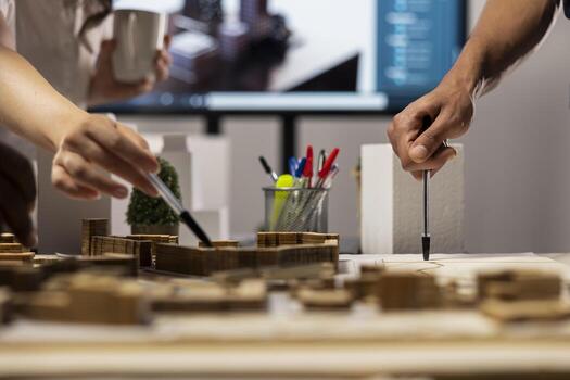 Close up of urban developers showing master plan for residential layout project, using 3D models on table to present idea of a smart city. Site preparation for infrastructure growth vision. photo