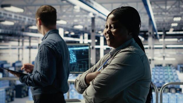 Portrait of smiling data center manager working to improve AI rigs processing speed and efficiency. Happy team leader in server hub manages gear to support artificial intelligence workloads, camera B photo
