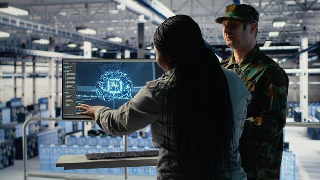 Army experts in server room use artificial intelligence program to review reconnaissance information. Military data center colleagues run machine learning systems to prepare missions, camera B photo
