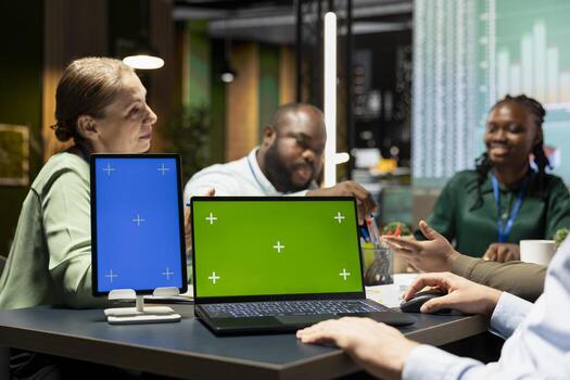 Multiethnic team of analysts enjoy a collaboration with copy space in a corporate firm after hours, discussing updates and exchanging documents. Diagrams to predict development outcomes. photo