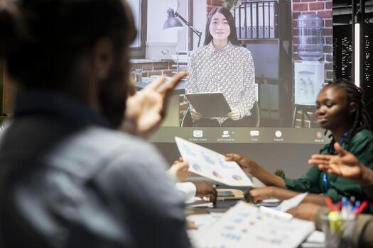 Multinational company staff in a briefing with CEO via call, global business meeting held to collaborate on development insights, review feedback and setting clear objectives for success. photo