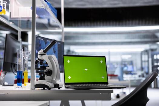 Isolated chroma key display on laptop in empty biolab setup with microscope and specimen tools. Workspace illustrates molecular biology research and biochemistry in healthcare science. photo