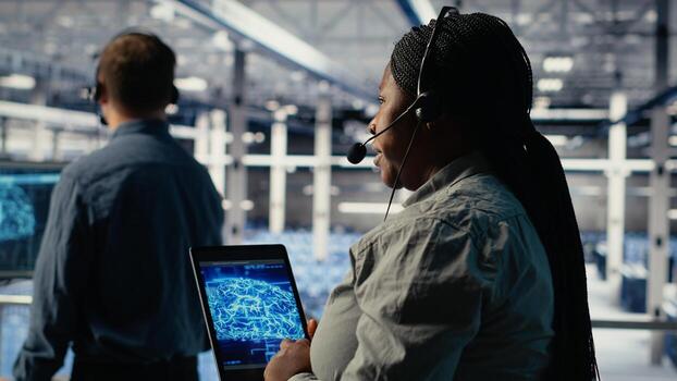 Team of data center programmers use AI to help customers resolve website hosting problems. Teamworking server farm tech support experts help users keep their online services running smoothly, camera B photo