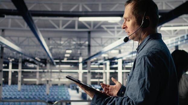 Server hub IT expert guides clients through setting up secure data backups to protect vital company information. Data center worker helps clients fix system errors on servers, camera A photo