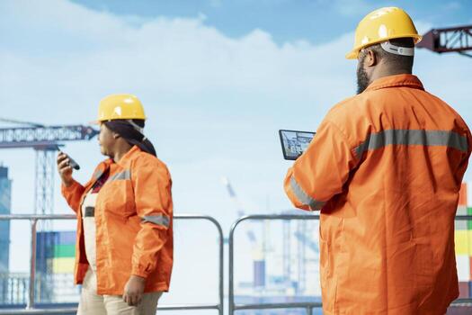 Offshore platform expert tracking oil production efficiency using tablet app. Drilling rig coworkers use device program to check equipment sensor readings, doing maintenance photo