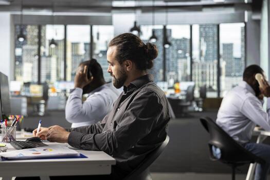 Business manager working on finance and budgeting at desk, consulting data archives and projections for development. Staff analyzing documents, diagrams and reports to meet goals. photo