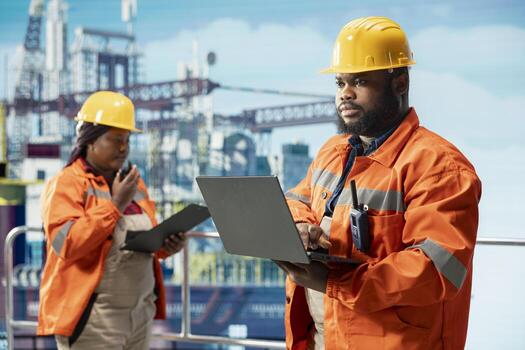 Offshore platform automation specialists configure vessel management systems for more efficient oil extraction. Drilling rig employees doing seabed analysis using advanced tools on laptop photo