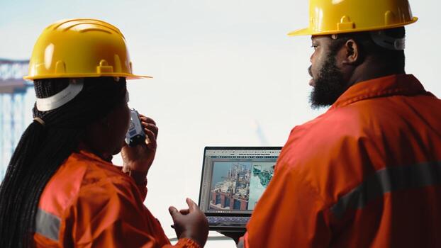 Drilling barge engineering team on deck studying geological maps to locate fossil fuel deposits. Offshore platform teamworking colleagues perform site assessment using digital mapping tech photo