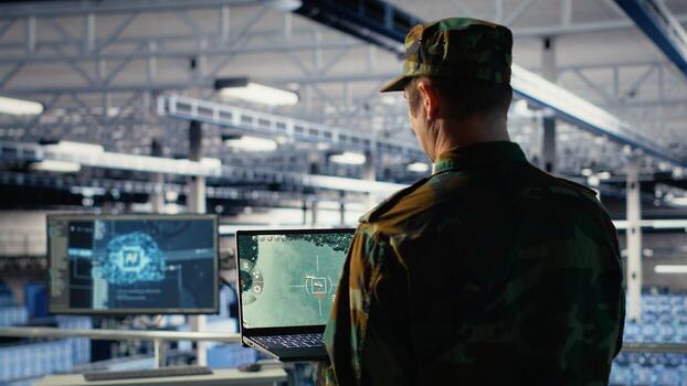 Military technician in data center tracking satellite coordinates using notebook software interface. Army unit in server hub analyzing reconnaissance data through satellite imaging systems, camera B photo
