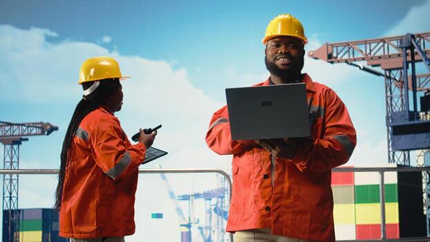 Man working on drilling rig ship, implementing safeguards to reduce ocean contamination. Environmental protection expert monitoring offshore platform carbon footprint using laptop, photo