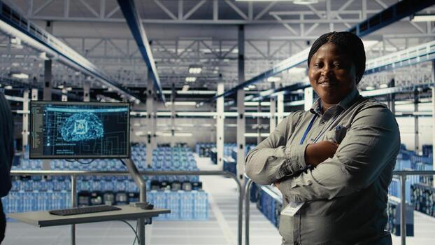 Portrait of smiling data center manager working to improve AI rigs processing speed and efficiency. Happy team leader in server hub manages gear to support artificial intelligence workloads, camera A photo