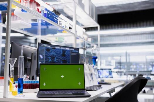 Green screen laptop and computer monitor in laboratory showing 3D molecular model visualization used for research. Mockup notebook and PC in medical lab displaying DNA data photo