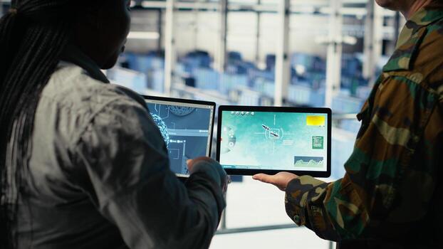 Close up of military data center colleagues looking at radar software to watch for enemy threats. Teamworking army staff members in data center scan suspicious activity to detect dangers, camera B photo