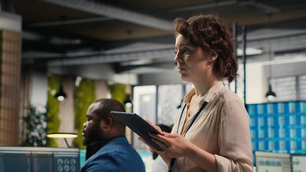 Pensive woman business leader does forecasting on her tablet in the office, working in a multinational company. Specialist using data analytics and insights for a development vision. photo