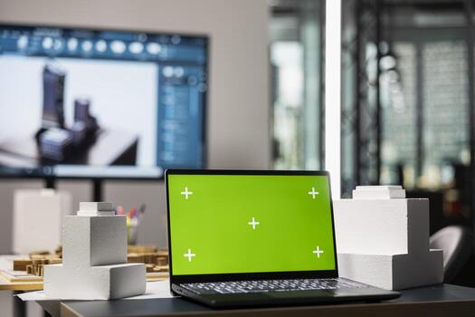 Empty desk layout in architectural real estate office with chroma key, building project preparation featuring property search documents and blueprints. Zoning regulations for approval. photo