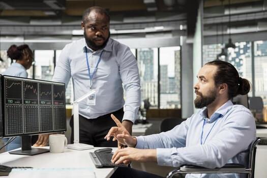 Risk analyst with disability and manager evaluate trading strategies to minimize losses. Supervisor overseeing man in wheelchair using data reports to assess financial markets volatility photo