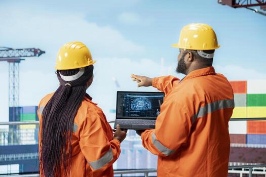 Offshore platform professionals using AI tech software on laptop to improve drilling accuracy. Coworkers use predictive artificial intelligence technology to prevent malfunctions photo