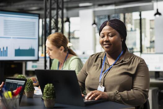 Ambitious team of diverse colleagues utilizes laptop in a corporate workspace, demonstrating productivity and teamwork with data insights and a visionary mindset. Fighting for development. photo