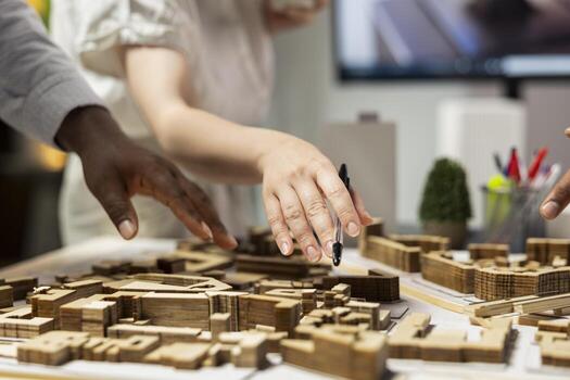 Close up of contractors arranging housing layout for urban site preparation, using 3D models for redevelopment and large scale construction project. Infrastructure growth and city planning. photo