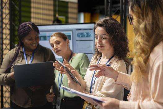 Women associates collaborating over performance metrics for a new financial strategy in a multinational company office. Business partners aligning resources with project objectives. photo