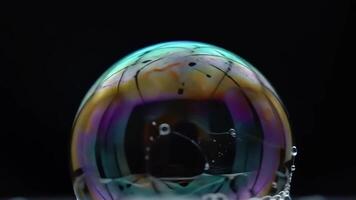 ipnotizzante iridescente sapone bolla macro su buio sfondo con vivace colori e dinamico liquido elementi astratto scienza concetto video