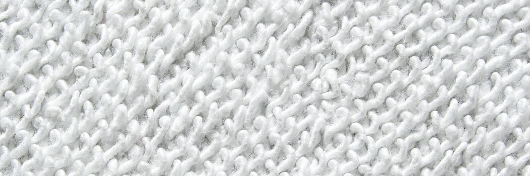 Close-up texture of white knitted fabric with intricate patterns and soft fibers visible. photo