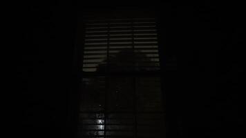 se av de fönster med persienner. blinkning lighte av åskväder reflekterande i de glas. stänga upp skott från inuti de byggnad video