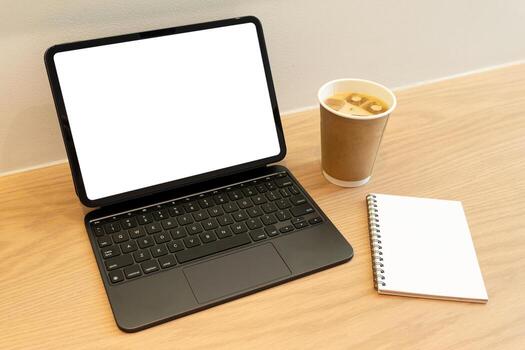 Blank White Screen on Tablet with keyboard at Workspace. a modern and minimalistic office or work from home environment. copy space on the screen and table surface for graphic elements. photo