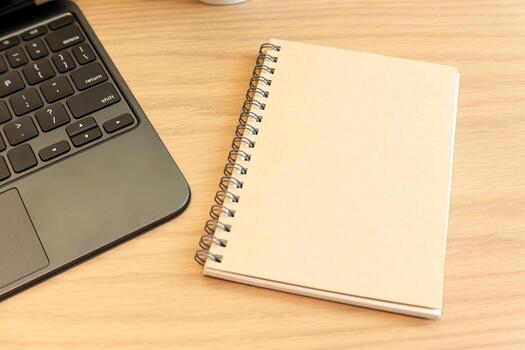 Minimal Workspace with Brown Spiral Notebook and Laptop on Wooden Desk. business, planning, creativity, and productivity. Ideal for background images, design templates, and work from home concepts. photo